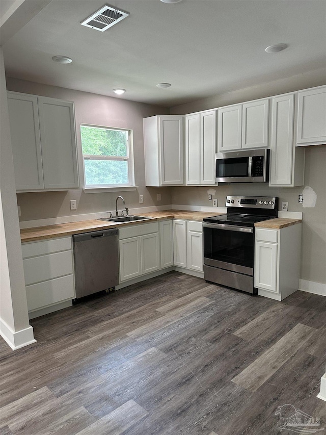 5661 Dupree Rd, Milton, FL 32570 - kitchen with appliances with stainless steel finishes, white cabinetry, recessed lighting, and dark wood-type flooring