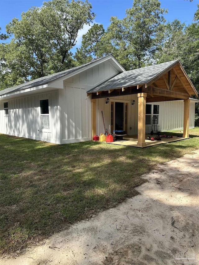 5661 Dupree Rd, Milton, FL 32570 - rear view of house with board and batten siding and a yard