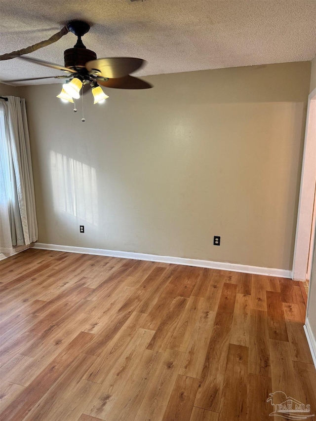 spare room with ceiling fan, plenty of natural light, a textured ceiling, and light hardwood / wood-style flooring