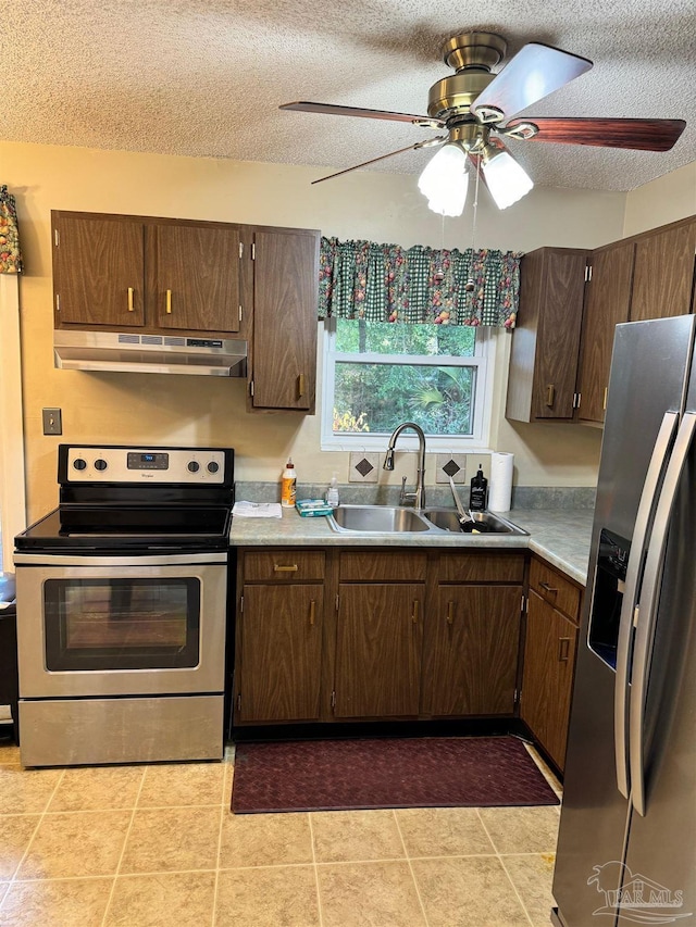 kitchen with sink, ceiling fan, a textured ceiling, range hood, and stainless steel appliances