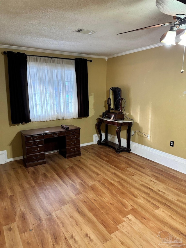 interior space with crown molding, ceiling fan, a textured ceiling, and light wood-type flooring