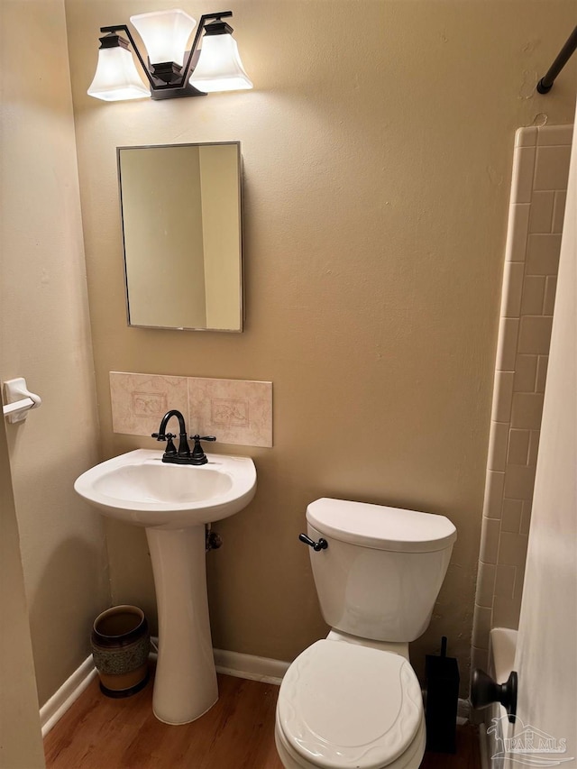 bathroom with hardwood / wood-style floors, toilet, and shower / bath combination