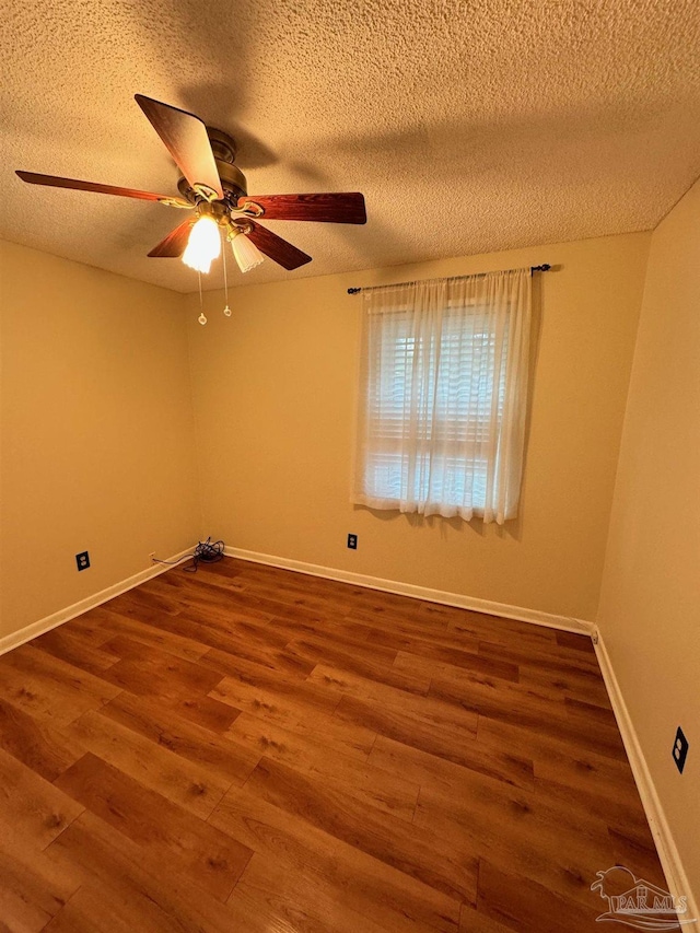 spare room with ceiling fan, wood-type flooring, and a textured ceiling