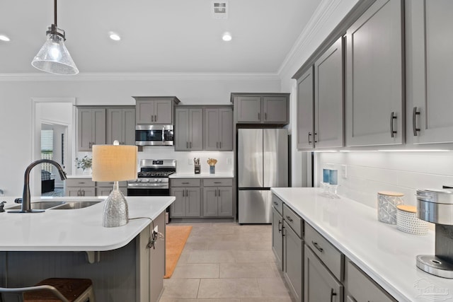 kitchen with gray cabinetry, appliances with stainless steel finishes, decorative backsplash, and a sink