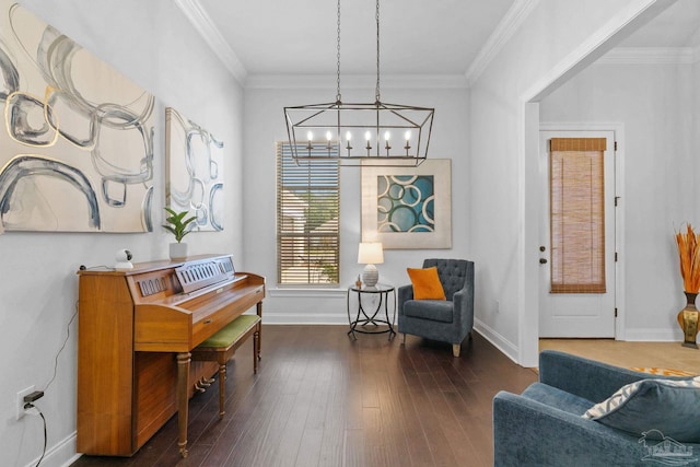 sitting room with a chandelier, ornamental molding, dark wood finished floors, and baseboards