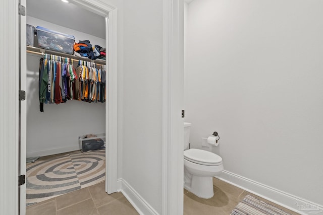 bathroom with toilet, tile patterned flooring, and baseboards