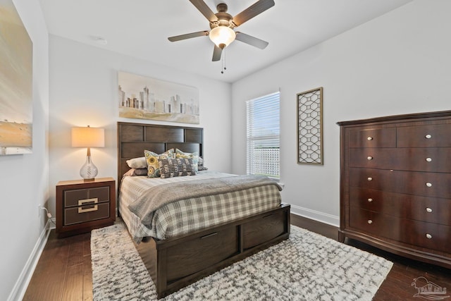 bedroom with dark wood-style floors, a ceiling fan, and baseboards