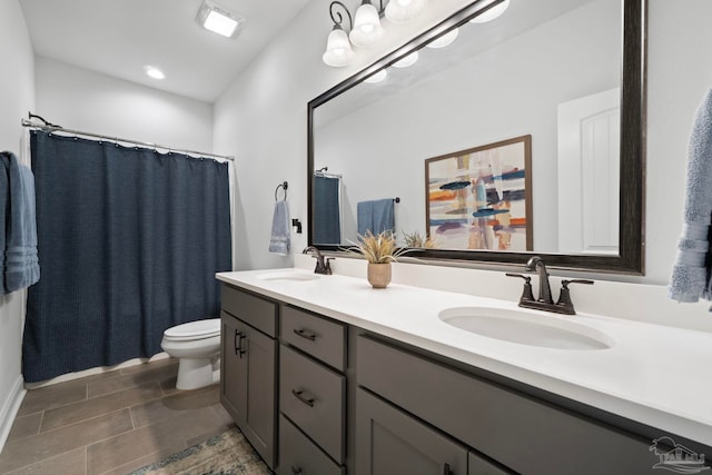 full bathroom featuring tile patterned floors, toilet, double vanity, and a sink