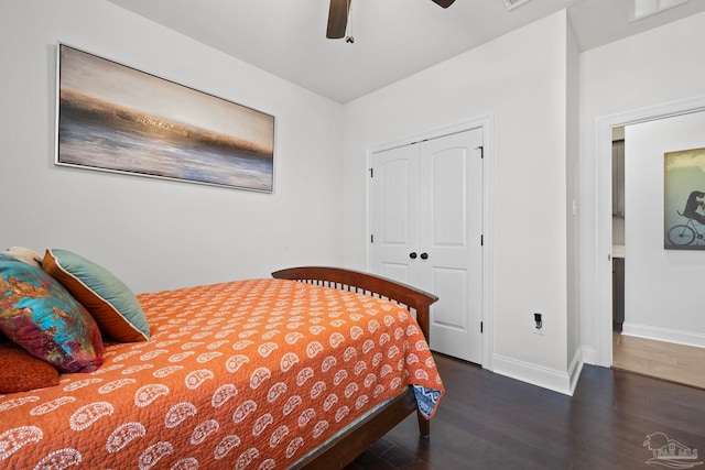 bedroom with wood finished floors, a closet, ceiling fan, baseboards, and visible vents