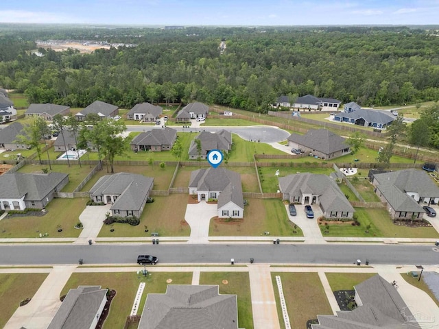 birds eye view of property featuring a wooded view and a residential view