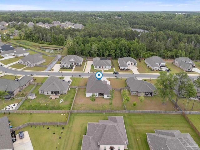 drone / aerial view featuring a wooded view and a residential view
