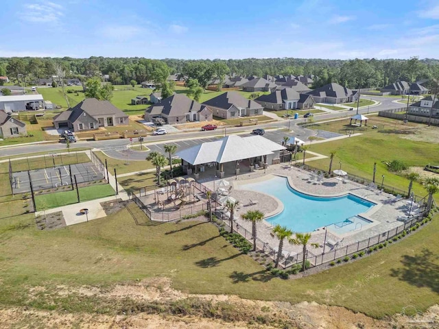 community pool featuring fence and a residential view