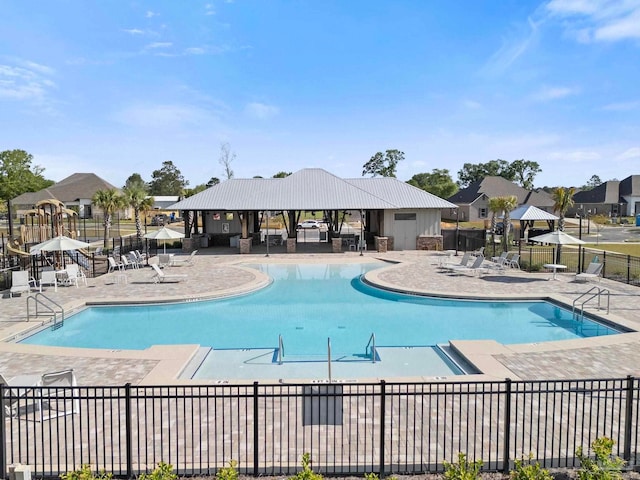 pool with a patio and fence