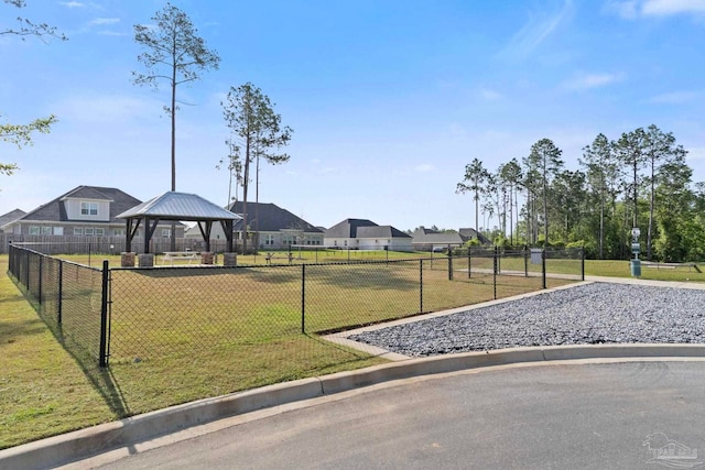 view of property's community with a lawn, a gazebo, and fence