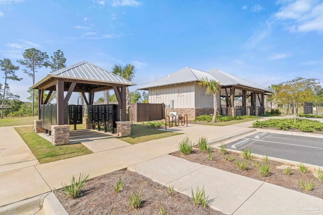 view of community with a gazebo, uncovered parking, and mail area