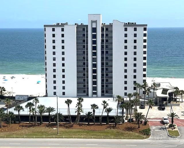 view of building exterior with a water view and a view of the beach