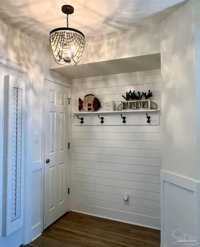 mudroom featuring dark wood-type flooring and a notable chandelier