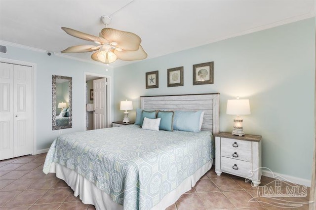 tiled bedroom with ceiling fan, a closet, and crown molding