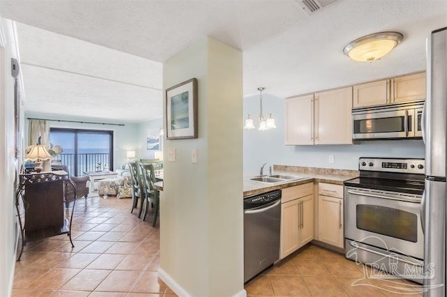 14623 Perdido Key Dr Unit W502, Pensacola, FL 32507 - kitchen with light tile patterned floors, an inviting chandelier, a sink, stainless steel appliances, and open floor plan