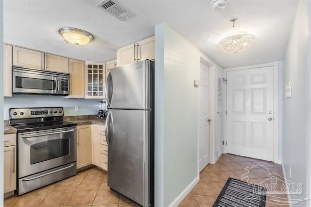 14623 Perdido Key Dr Unit W502, Pensacola, FL 32507 - kitchen featuring baseboards, light tile patterned floors, dark countertops, visible vents, and appliances with stainless steel finishes