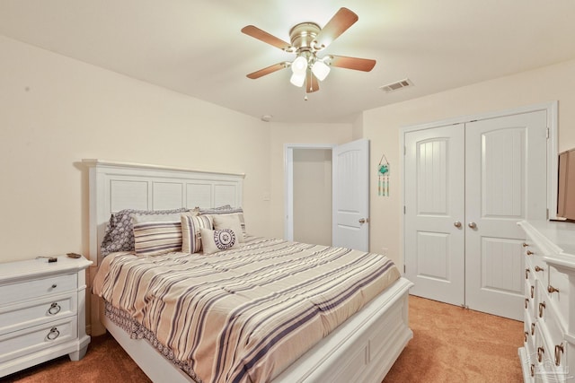 carpeted bedroom with ceiling fan and a closet