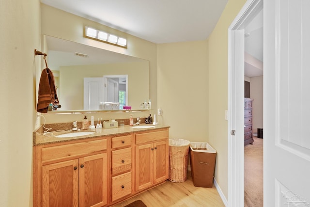 bathroom with double sink vanity and hardwood / wood-style flooring