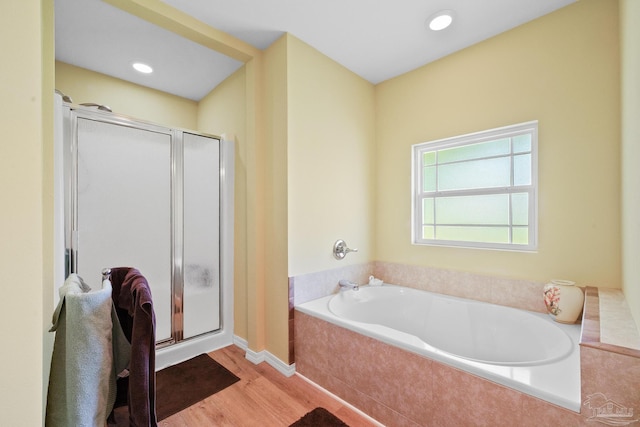 bathroom with hardwood / wood-style flooring and separate shower and tub