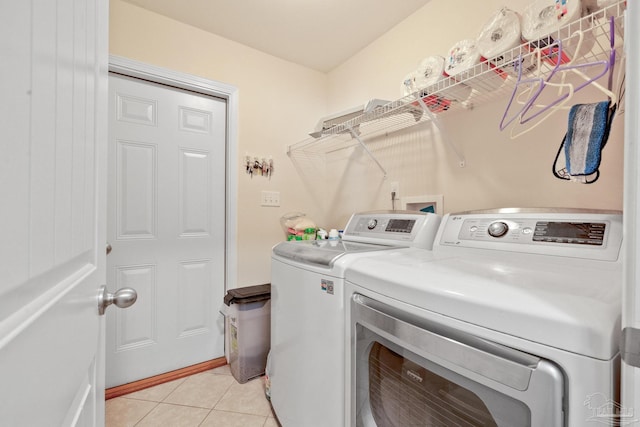 washroom featuring light tile patterned floors and washer and clothes dryer