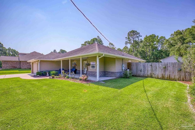 back of property featuring a lawn and covered porch