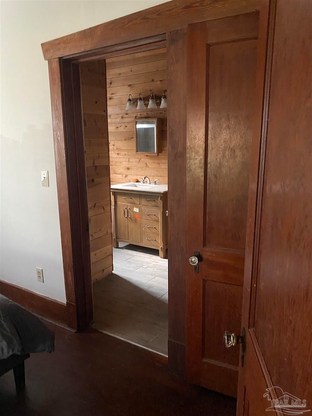 hallway featuring wooden walls and sink