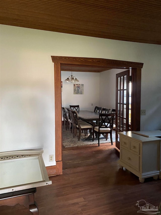 dining area with an inviting chandelier and dark wood-type flooring