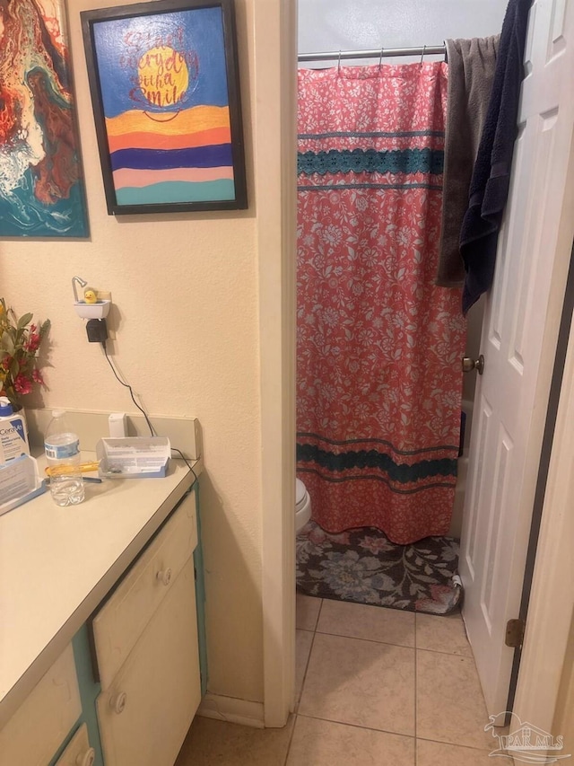 bathroom with tile patterned flooring, toilet, vanity, and a shower with curtain