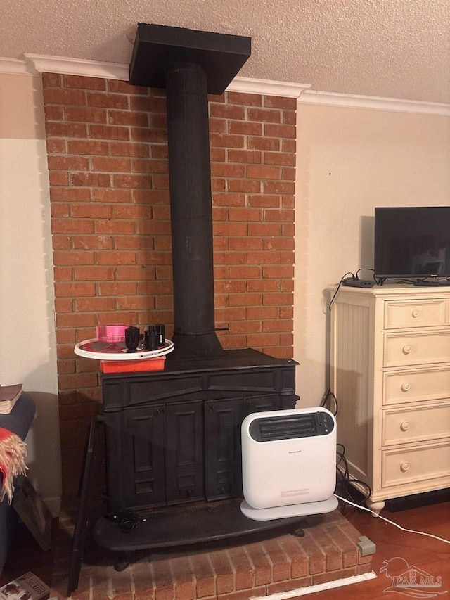 details featuring ornamental molding, a wood stove, and a textured ceiling