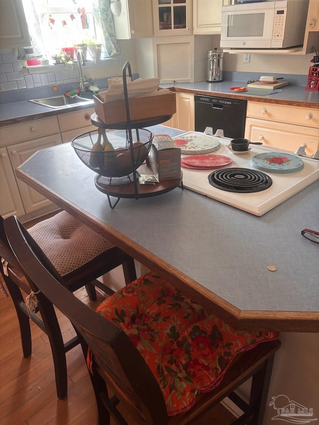 kitchen featuring black dishwasher, sink, and light hardwood / wood-style flooring