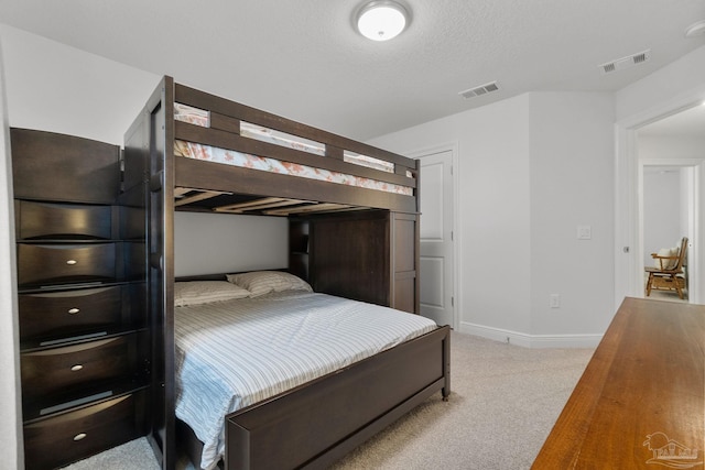 bedroom with light carpet and a textured ceiling