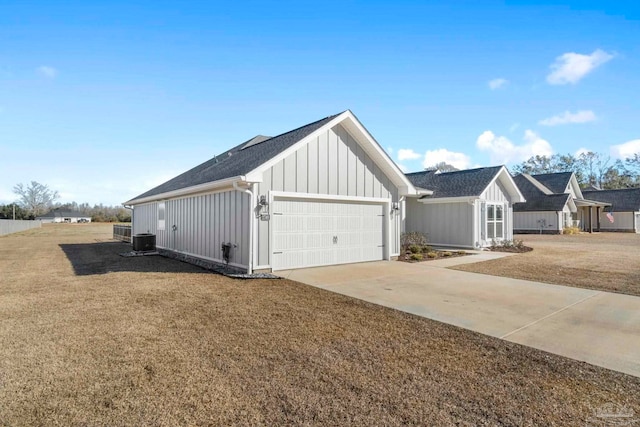 view of side of home with a garage, central air condition unit, and a yard