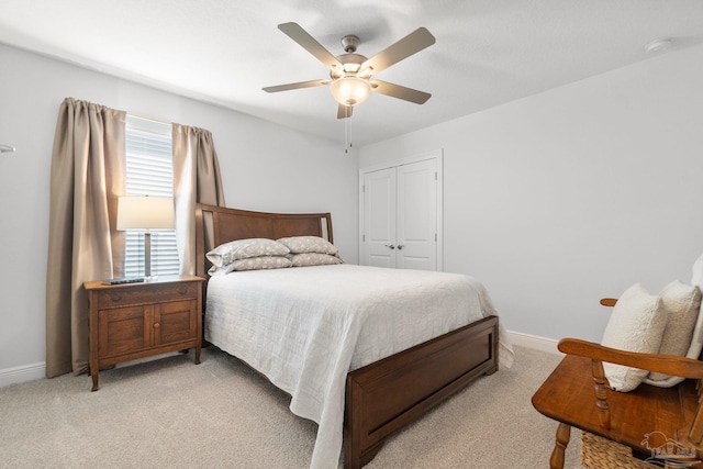 bedroom featuring ceiling fan, light colored carpet, and a closet