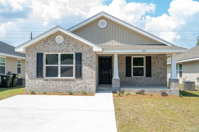 view of front of home featuring central AC, covered porch, and a front lawn