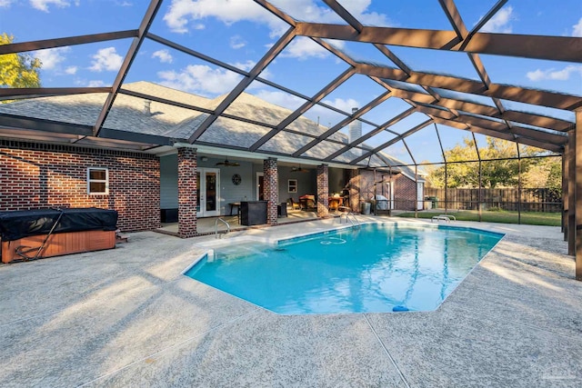 view of pool with a hot tub, ceiling fan, a lanai, and a patio area