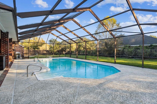 view of pool featuring glass enclosure, a patio area, and a yard