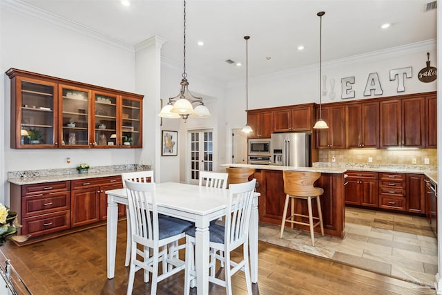 kitchen featuring a breakfast bar, a center island, hanging light fixtures, dark hardwood / wood-style floors, and stainless steel appliances