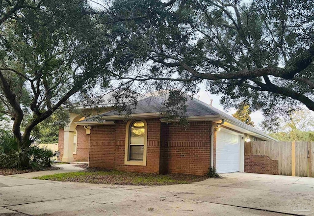 1358 Windsor Park Rd, Gulf Breeze, FL 32563 - view of side of home featuring a garage, concrete driveway, brick siding, and roof with shingles