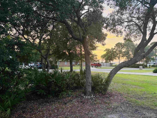 1358 Windsor Park Rd, Gulf Breeze, FL 32563 - yard at dusk featuring a lawn
