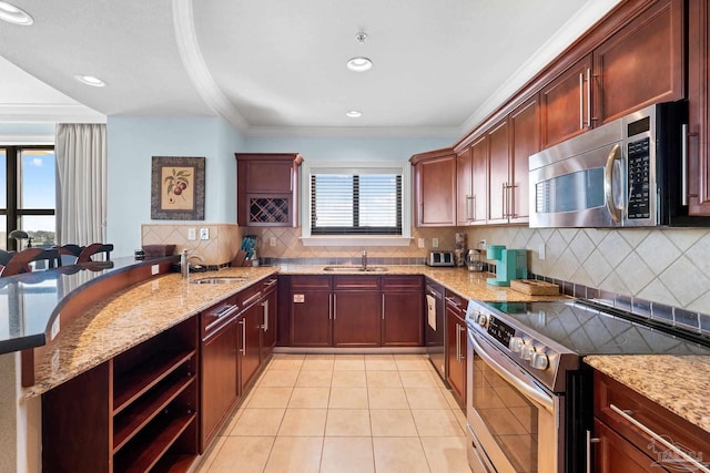 kitchen featuring sink, crown molding, a kitchen bar, and stainless steel appliances