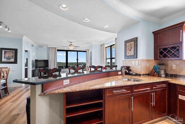 kitchen with kitchen peninsula, a textured ceiling, sink, and ceiling fan