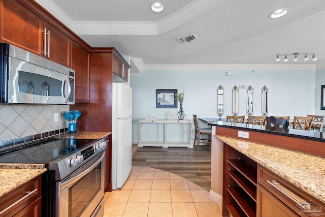 kitchen featuring decorative backsplash, appliances with stainless steel finishes, light hardwood / wood-style flooring, crown molding, and light stone counters