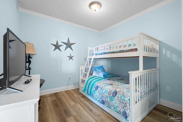 bedroom featuring ornamental molding, hardwood / wood-style floors, and a textured ceiling