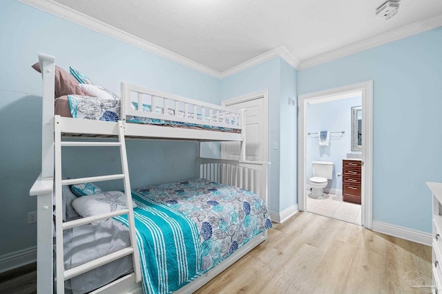 bedroom featuring crown molding, a textured ceiling, connected bathroom, and light wood-type flooring