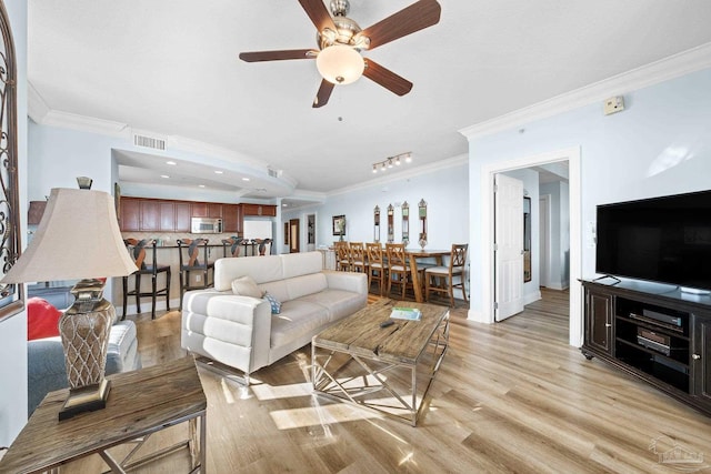 living room with crown molding, light wood-type flooring, and ceiling fan