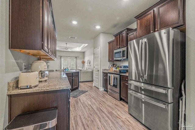 kitchen with stainless steel appliances, light wood finished floors, dark brown cabinets, a ceiling fan, and recessed lighting